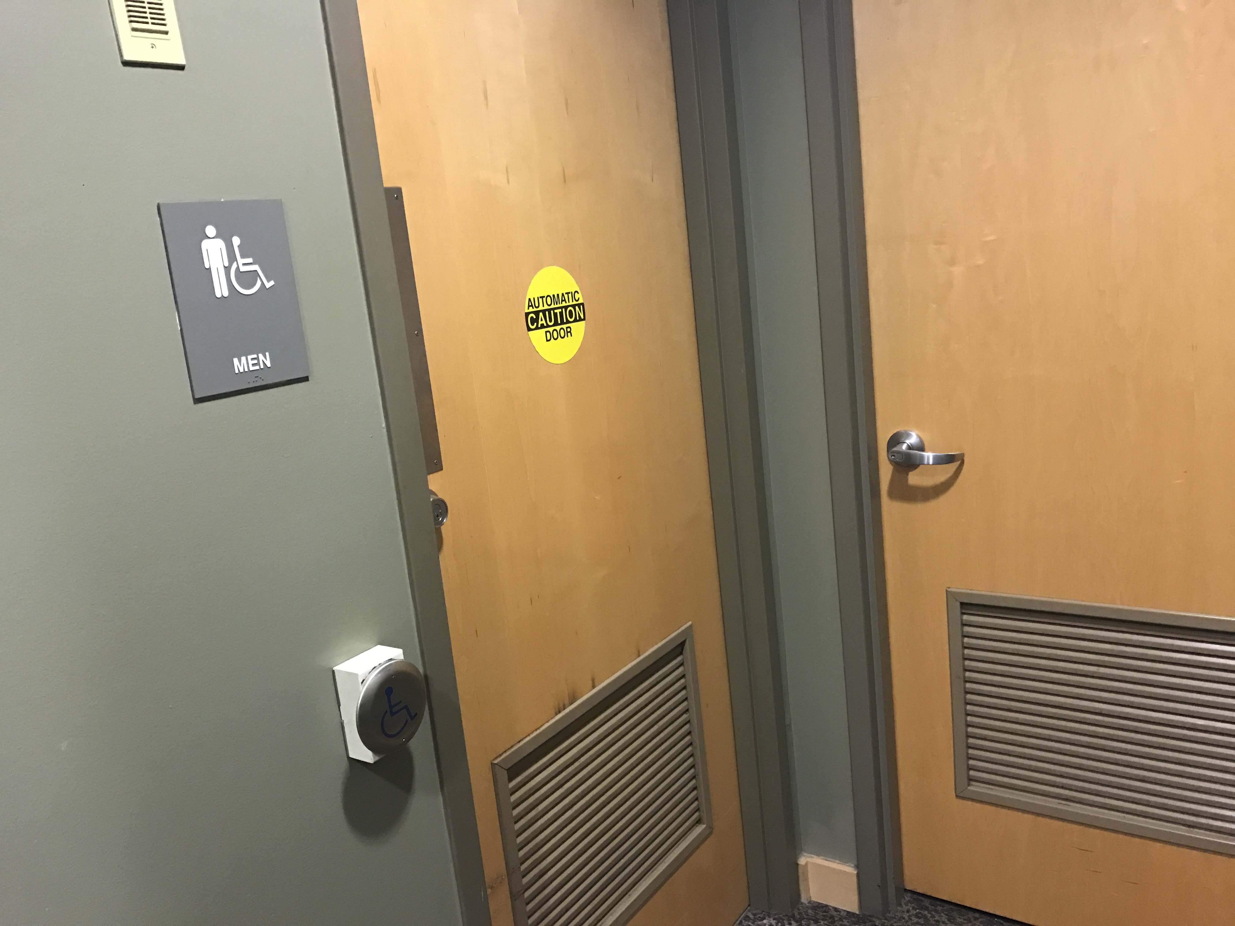 Mens restroom door with accessible door opener.