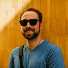 Ian wearing sunglasses on a sunny backdrop